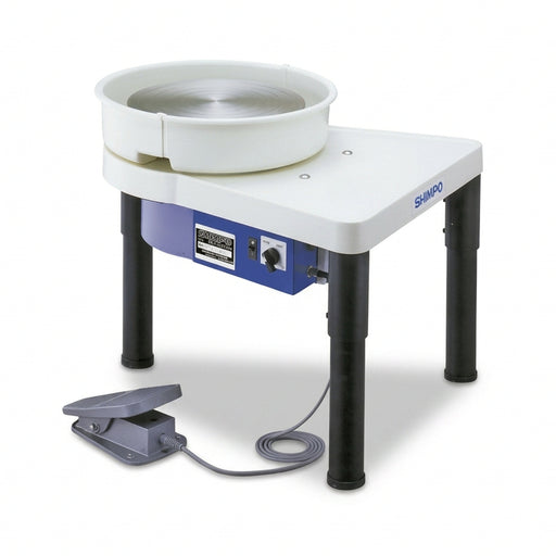 A Shimpo VL Whisper Pottery Wheel with a white wheel-head on a blue and white base, with adjustable black legs and a pedal.